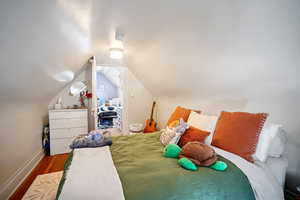 Bedroom featuring lofted ceiling and hardwood / wood-style floors