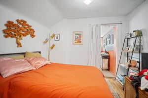 Bedroom featuring lofted ceiling and light hardwood / wood-style flooring