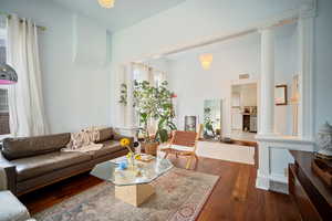 Living room with hardwood / wood-style floors and ornate columns