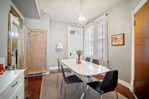 Dining area with dark hardwood / wood-style flooring, a wealth of natural light, and a textured ceiling