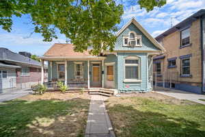 View of front of house with covered porch and a front lawn