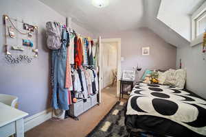 Carpeted bedroom featuring vaulted ceiling