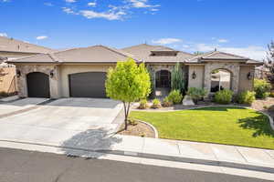 View of front facade featuring a garage and a front yard