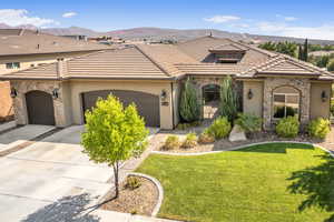 Mediterranean / spanish-style home with a mountain view, a garage, and a front lawn