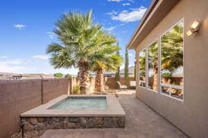 View of pool with an in ground hot tub and a patio