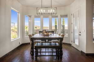 Dining room with dark wood-type flooring and a chandelier