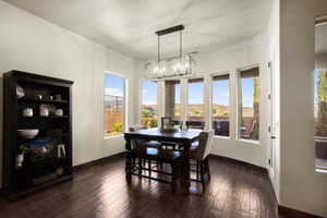 Dining room featuring a mountain view, a notable chandelier, and dark hardwood / wood-style floors