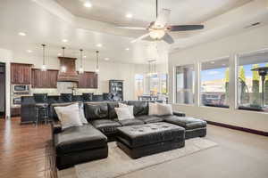 Living room with ceiling fan and dark hardwood / wood-style floors