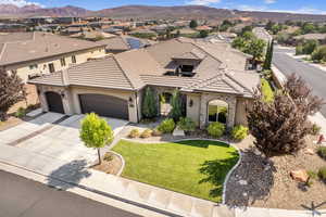 Mediterranean / spanish home featuring a mountain view, a garage, and a front lawn