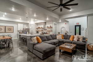 Living room featuring a textured ceiling, ceiling fan, and sink