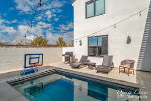 View of swimming pool with area for grilling and a patio area