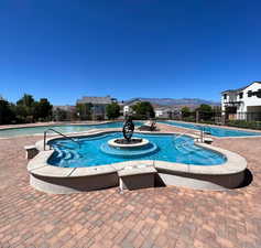 View of swimming pool featuring a mountain view, a hot tub, and a patio area