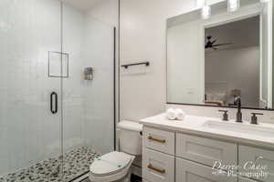 Bathroom with vanity, toilet, and an enclosed shower