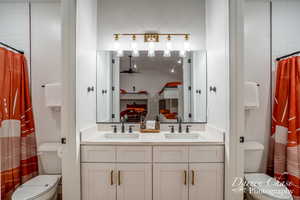 Bathroom with vanity, toilet, walk in shower, and vaulted ceiling