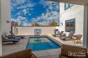 View of swimming pool with a grill and a patio