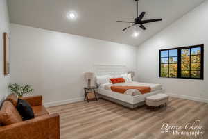 Bedroom featuring light hardwood / wood-style flooring, ceiling fan, and high vaulted ceiling