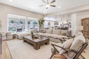 Living room featuring a healthy amount of sunlight, ceiling fan, and light hardwood / wood-style flooring