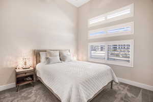 Bedroom featuring a towering ceiling and carpet