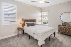 Carpeted bedroom featuring ceiling fan