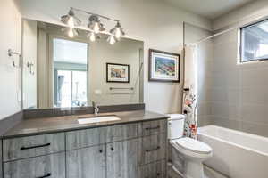 Full bathroom with vanity, toilet, and shower / bath combo with shower curtain