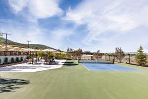 View of tennis court featuring basketball hoop