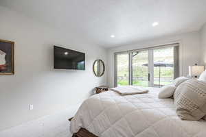 Bedroom featuring carpet and a textured ceiling