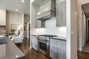 Kitchen with premium range hood, gray cabinetry, a textured ceiling, high end stainless steel range oven, and dark hardwood / wood-style floors