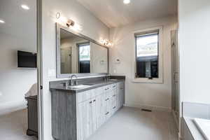 Bathroom featuring tile patterned flooring, a textured ceiling, vanity, and a shower with door