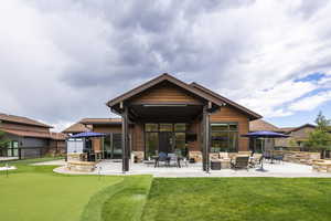 Rear view of property featuring an outdoor living space with a fireplace and a patio area