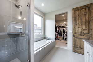 Bathroom with tile patterned floors and shower with separate bathtub