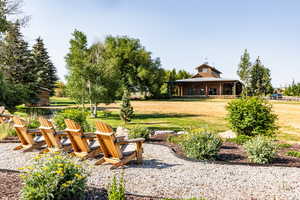 Surrounding community featuring an outdoor fire pit and a lawn