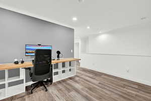 Home office with hardwood / wood-style flooring and ornamental molding