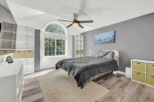 Bedroom featuring lofted ceiling, light hardwood / wood-style flooring, and ceiling fan