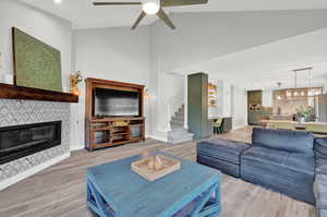 Living room featuring vaulted ceiling, hardwood / wood-style floors, and ceiling fan