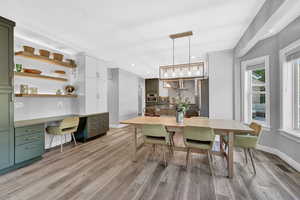 Dining space featuring light wood-type flooring and built in desk