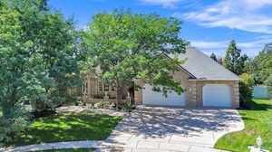 View of front of home with a garage and a front lawn