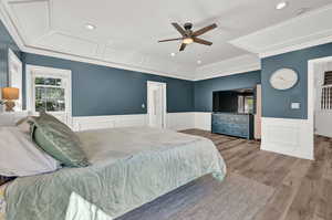 Bedroom with light wood-type flooring, ceiling fan, and ornamental molding