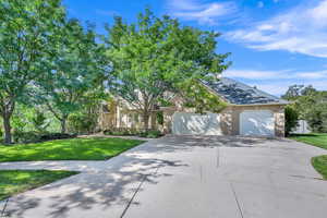 Obstructed view of property with a garage and a front lawn