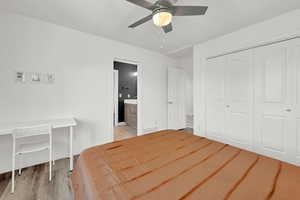 Bedroom featuring light hardwood / wood-style flooring, ensuite bathroom, ceiling fan, and a closet