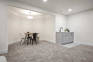 Dining room featuring sink and light colored carpet