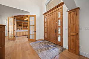 Foyer entrance with french doors and light hardwood / wood-style flooring