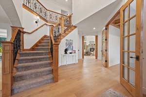 Stairway with crown molding, french doors, and hardwood / wood-style flooring