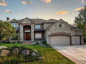 View of front of house with a garage and a yard