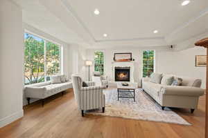 Living room with a wealth of natural light, a fireplace, and light hardwood / wood-style floors