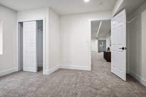 Unfurnished bedroom with a closet and light carpet