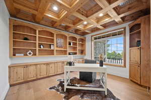 Home office with wooden ceiling, coffered ceiling, beamed ceiling, and light hardwood / wood-style flooring