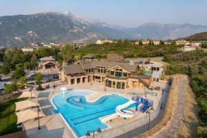 View of pool with a water slide, a mountain view, and a patio area