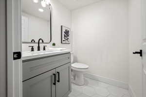 Bathroom featuring vanity, toilet, and tile patterned floors