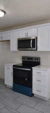 Kitchen with appliances with stainless steel finishes and white cabinets