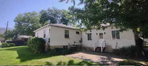 Back of house featuring a yard